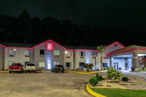 卡罗尔顿Red Roof Inn & Suites Carrollton, GA - West Georgia的夜间酒店,停车场内有车辆停放