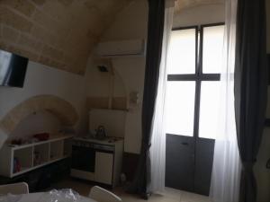阿尔塔穆拉La casa di Carol的厨房设有窗户,墙上有十字架