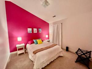 默特尔比奇Lovely Home Near Myrtle Beach的卧室设有粉红色的墙壁和一张床