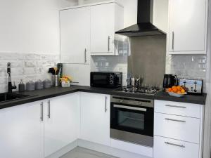 贝尔法斯特Harland View Apartment的厨房配有白色橱柜和炉灶烤箱。