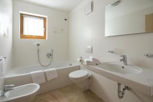 科瓦拉因巴迪亚Ciasa Vilin的白色的浴室设有浴缸、卫生间和水槽。