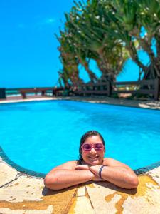 嘎林海斯港Mar a Vista的戴太阳镜的女人站在游泳池前