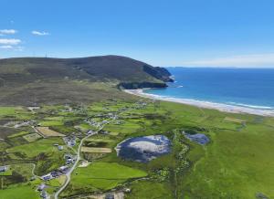 RiverSarlyn Holiday Home Achill的享有毗邻大海的高尔夫球场的空中景致