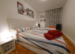 潘普洛纳Apartamento Saioa的一间卧室配有一张带红色毛巾的床