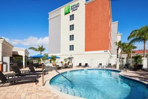 圣露西港Holiday Inn Express Hotel & Suites Port St. Lucie West, an IHG Hotel的大楼前设有游泳池的酒店