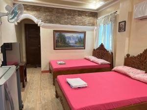 阿拉米诺斯Vhauschild Transient Rooms -B的一间设有两张粉红色床单的床的房间