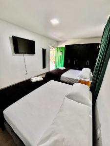 金巴亚Yellow House的一间卧室配有两张床和一台平面电视