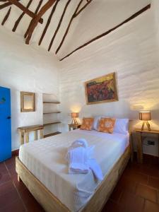 巴里查拉El Principito Hospedaje的卧室配有白色的床和毛巾
