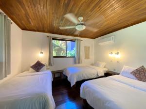 蒙特苏马Casa Colores的一间卧室配有两张床和吊扇