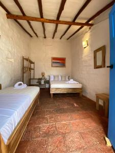 巴里查拉El Principito Hospedaje的一间设有两张床的房间,内设一张长凳