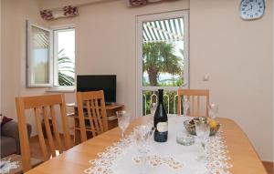 卡什泰拉Gorgeous Home In Kastel Gomilica With Wifi的用餐室配有带1瓶葡萄酒的桌子