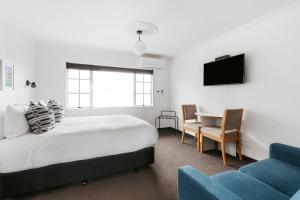 芒格努伊山弥生贝尔汽车旅馆的一间卧室配有一张床、一张桌子和一张沙发