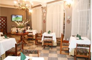 HuancavelicaHotel Presidente Huancavelica - Asociado Casa Andina的餐厅配有白色的桌椅和吊灯