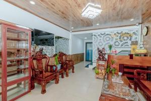 大叻Moc Nhien Hostel Da Lat的客厅配有椅子、桌子和墙壁