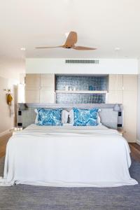 汉密尔顿岛海滩俱乐部酒店的卧室配有带蓝色枕头的大型白色床