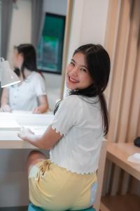 Ban Khlong Chi LatTiny Krabi Hotel的女人在浴室水槽前微笑