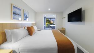 皇后镇Oaks Queenstown Shores Resort的一间酒店客房,配有一张大床和一台平面电视