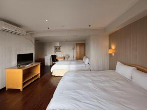 新竹荷米斯饭店 的酒店客房设有两张床和一台平面电视。