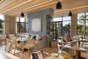 麦纳麦Jumeirah Gulf of Bahrain Resort and Spa的用餐室设有桌椅和窗户。