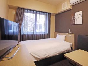 多贺城市路线宾馆 - 多贺城站东的酒店客房设有床和窗户。