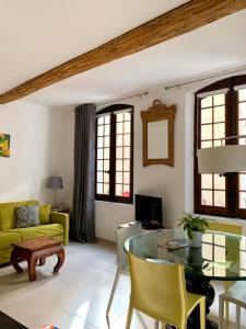 穆斯捷-圣玛丽La Maison du Courtil, Citron-Caramel的客厅配有玻璃桌和黄色椅子