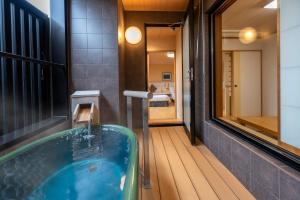 青梅市KAMENOI HOTEL Ome的浴室配有浴缸及镜子