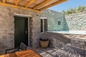 普拉迪斯亚罗斯Mykonos Drops的庭院设有游泳池、桌子和椅子。