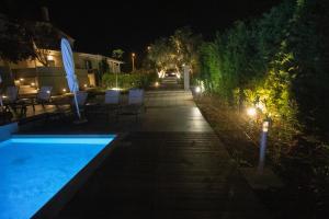 尼坡帝8 Boutique Suites的夜间后院,设有游泳池和灯光