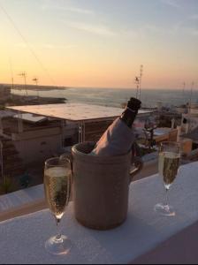 滨海波利尼亚诺FONTEblu B&B的一张桌子上的冰桶里装着一瓶香槟,带两杯