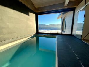 安格勒Artik chalet avec vue à 180 degrés et piscine的房屋内带窗户的游泳池