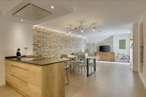 EspuéndolasOS ORMOS Casa Rural - Apartamentos - Habitaciones的一间厨房和带石墙的用餐室