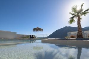 巴利恩Mayana Luxury Villa, an infinite blue experience, by ThinkVilla的一座棕榈树和山脉环绕的游泳池