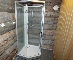 萨利色尔卡Kuukkeli Log Houses Porakka Inn的浴室里设有玻璃门淋浴