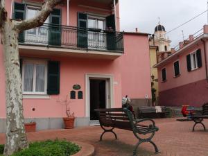 东塞斯特里La Piazzetta的粉红色建筑前的公园长凳