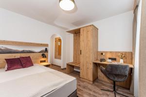 Tauplitzalm希尔泽格酒店的一间卧室配有一张床和一张书桌