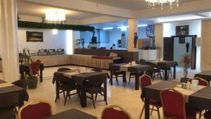 埃尔比勒Hotel Sinaia Palace的餐厅内带桌椅的用餐室