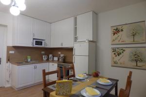 ChrastavaApartmán v Bételu的厨房配有白色橱柜和桌椅