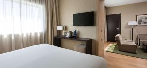 马德里NH马德里里贝拉格兰德曼萨纳雷斯酒店的酒店客房,配有床和电视