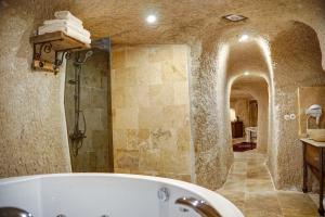 乌奇希萨尔Karma Suites Cappadocia的带浴缸和步入式淋浴间的浴室