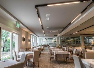 米兰马瑞提那贝莱蒂尼酒店 的餐厅设有白色的桌椅和窗户。
