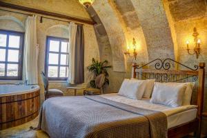乌奇希萨尔Karma Suites Cappadocia的卧室配有床和浴缸