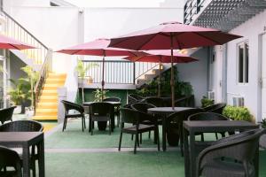 BalangaGrand Peninsula Suites的一个带桌椅和遮阳伞的户外庭院。