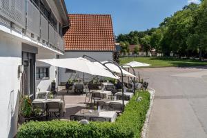 涅德托辛根Gasthaus Hotel Zum Mohren的一个带桌椅和遮阳伞的户外庭院。