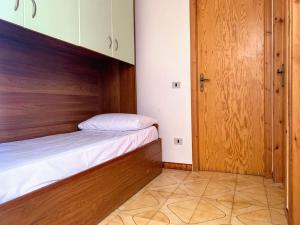 斯卡莱阿Brain Apartment Scalea - Parco Edil Blu的一间小卧室,配有一张床和一扇木门