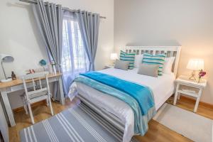 蒙塔古Mirihof Retreat and Olive Estate的一间卧室配有一张床、一张书桌和一个窗户。