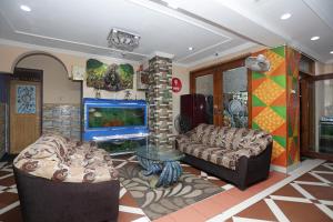 普里Hotel Ashraya的客厅配有两张沙发和一台电视机