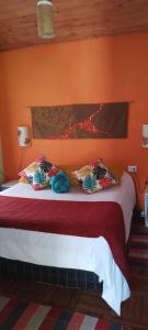 圣本图-杜萨普卡伊chales azaleia todos的一间卧室配有一张带橙色墙壁的大床