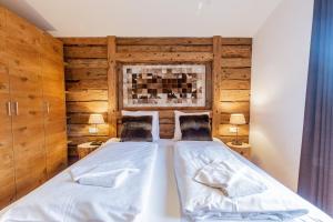 滨湖采尔Chalet Hohe Tauern - Steinbock Lodges的卧室设有两张木墙