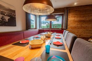 滨湖采尔Chalet Hohe Tauern - Steinbock Lodges的一间带长桌和椅子的用餐室