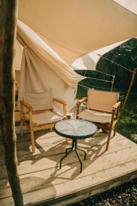 贝都古Alamu Eco Lodge的一张桌子、两把椅子和一个帐篷